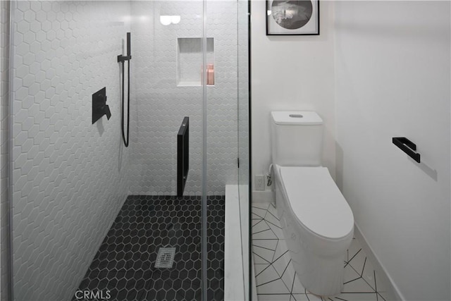 full bath featuring a stall shower, tile patterned flooring, and toilet