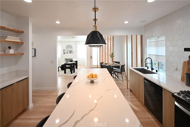 kitchen featuring a sink, light wood-style floors, brown cabinets, dishwasher, and modern cabinets