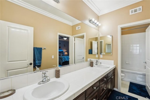 ensuite bathroom with crown molding, visible vents, and a sink