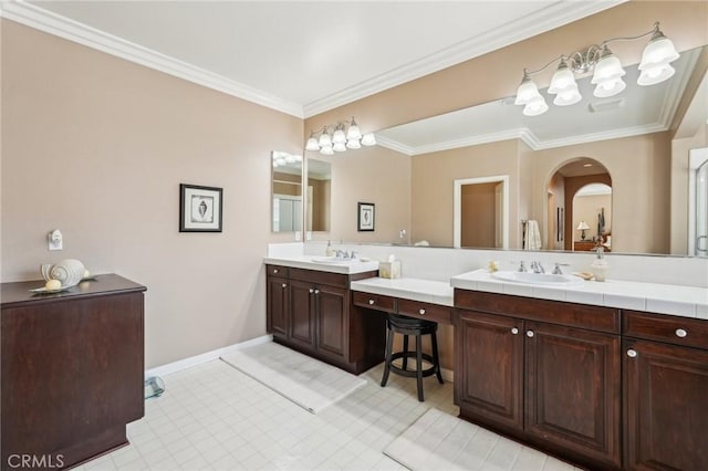 bathroom with vanity, crown molding, and baseboards