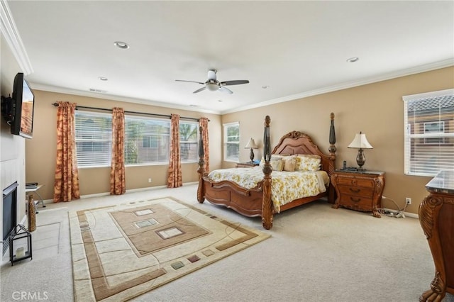 carpeted bedroom with baseboards, ornamental molding, recessed lighting, a glass covered fireplace, and a ceiling fan