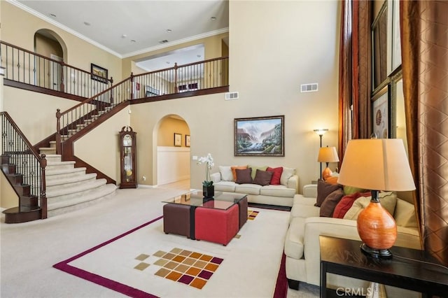 living room with arched walkways, visible vents, carpet floors, and ornamental molding