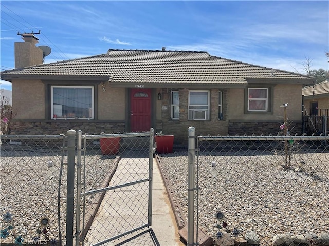 view of front of house featuring stone siding, a fenced front yard, a chimney, and stucco siding