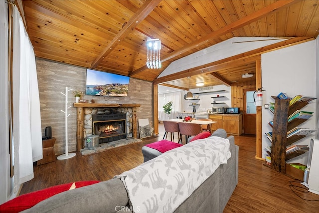 living area with vaulted ceiling with beams, wooden ceiling, wooden walls, a fireplace, and wood finished floors