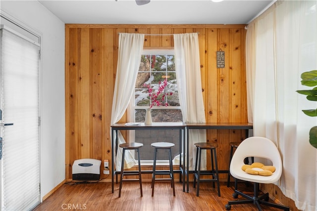 sitting room featuring wood finished floors and wooden walls