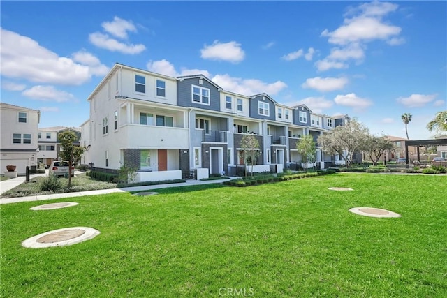 exterior space with a residential view, a front lawn, and stucco siding