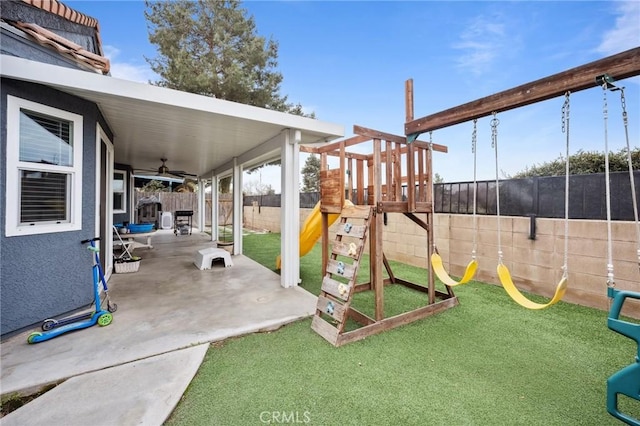 view of patio featuring a fenced backyard, ceiling fan, and a playground