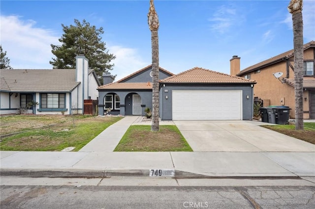 view of front of property featuring a chimney, stucco siding, a garage, driveway, and a tiled roof