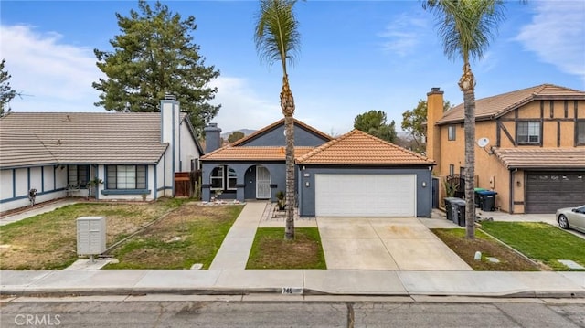 view of front facade with an attached garage, driveway, a tiled roof, stucco siding, and a front lawn