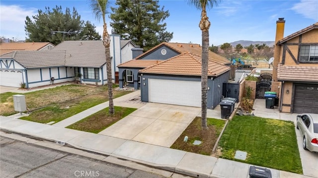 view of front of home with a tile roof, an attached garage, a front yard, a gate, and driveway