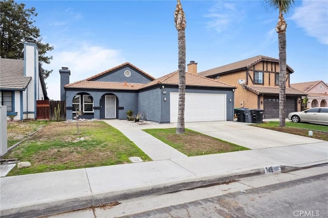 view of front facade featuring a tiled roof, concrete driveway, a chimney, and a garage