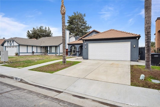 ranch-style house with an attached garage, a tiled roof, driveway, stucco siding, and a front lawn