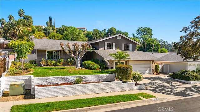 view of front facade featuring driveway, a garage, fence, and a front yard