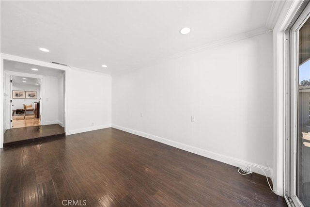 spare room with baseboards, visible vents, ornamental molding, dark wood-type flooring, and recessed lighting