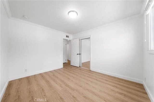 unfurnished bedroom featuring light wood finished floors, baseboards, visible vents, and ornamental molding