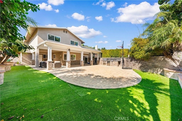 back of property featuring a lawn, a patio area, an outdoor living space, and stucco siding