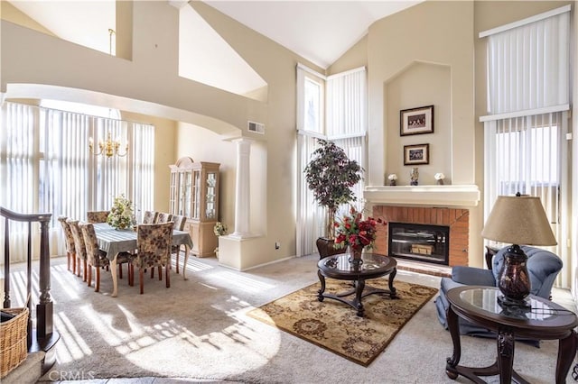 living room with arched walkways, visible vents, carpet flooring, high vaulted ceiling, and ornate columns