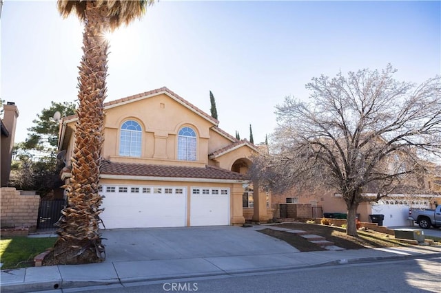 view of front of home featuring a garage, concrete driveway, a tiled roof, and stucco siding