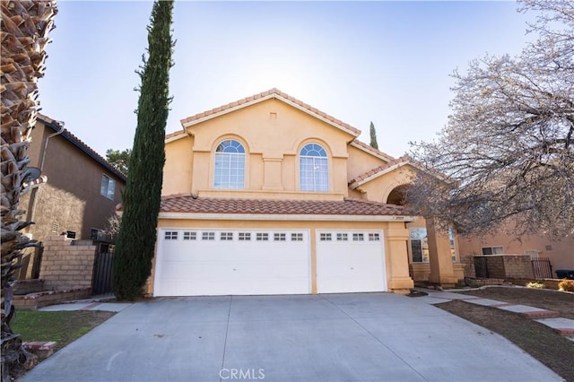 mediterranean / spanish-style house with driveway, a tile roof, a garage, and stucco siding