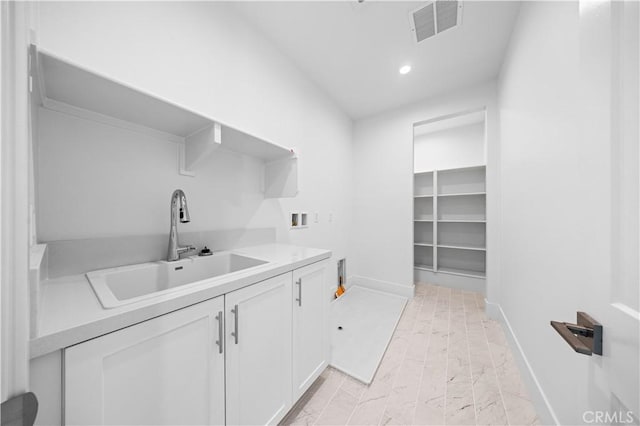 laundry room with cabinet space, baseboards, visible vents, hookup for a washing machine, and a sink