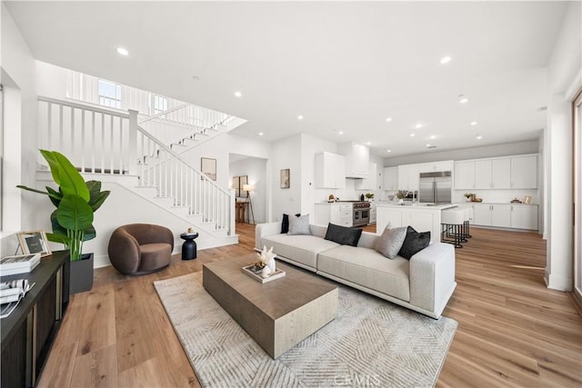 living room featuring stairs, recessed lighting, and light wood-style floors