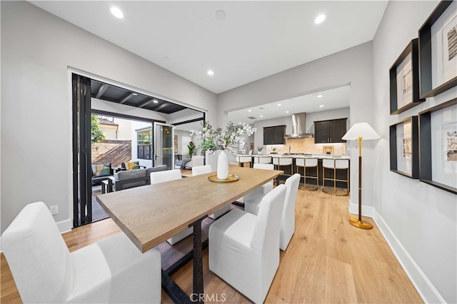 dining room featuring light wood-style flooring, baseboards, and recessed lighting