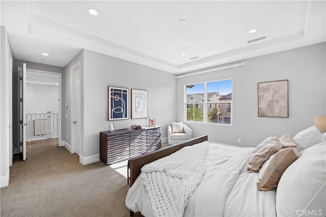 carpeted bedroom with baseboards, visible vents, a tray ceiling, and recessed lighting