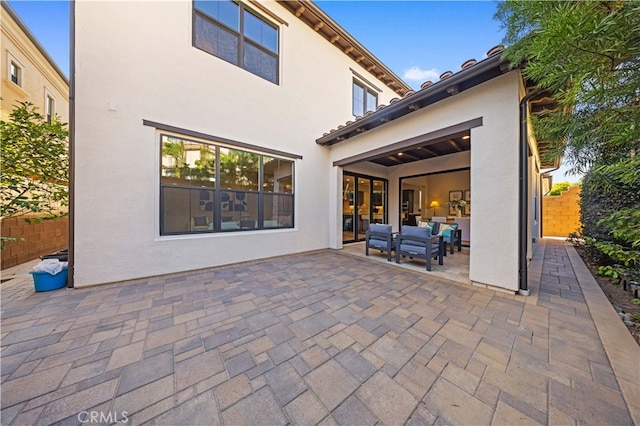 back of property with stucco siding, fence, an outdoor hangout area, and a patio