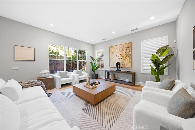 living area featuring baseboards, visible vents, wood finished floors, and recessed lighting