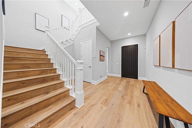 entryway with light wood-style flooring, recessed lighting, visible vents, baseboards, and stairway