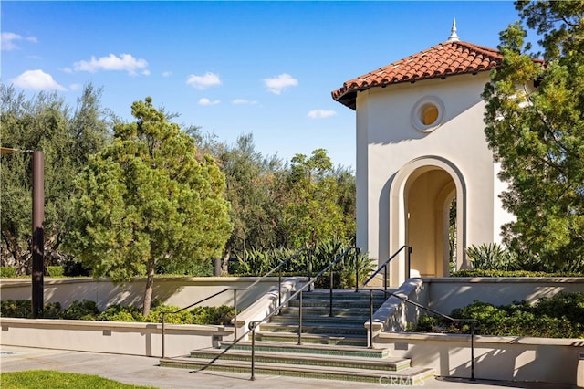 exterior space with stucco siding and a tiled roof