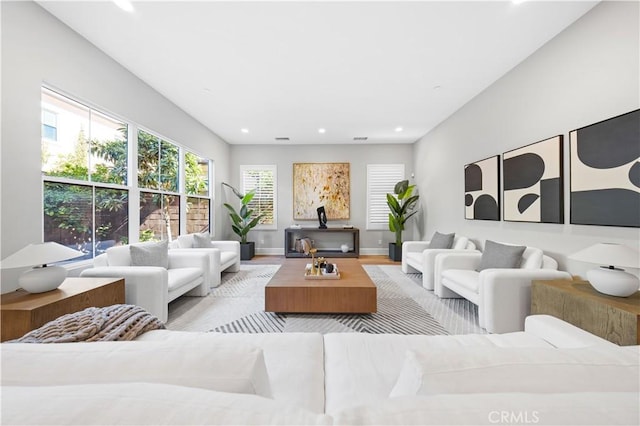 living room with recessed lighting, baseboards, and wood finished floors