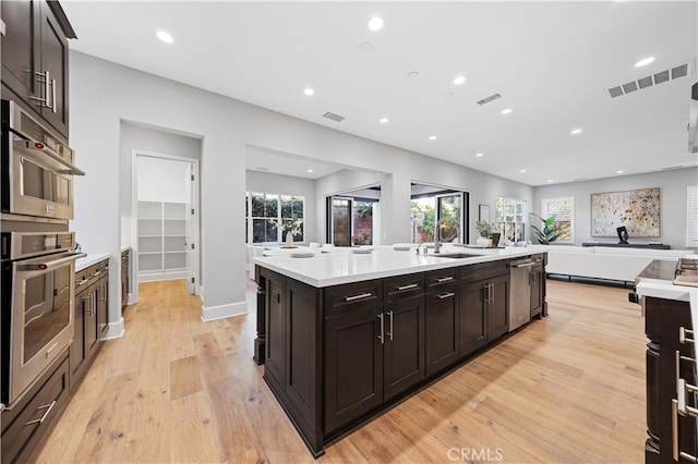 kitchen featuring open floor plan, light countertops, a sink, and visible vents