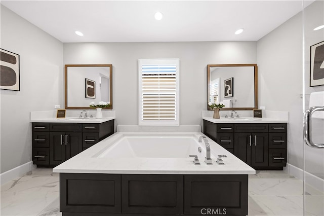 full bath with a garden tub, marble finish floor, a sink, and recessed lighting