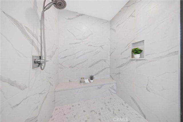 bathroom featuring a marble finish shower