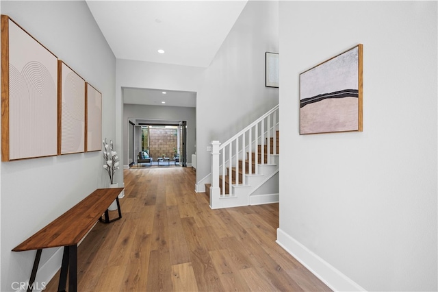 foyer with stairs, baseboards, wood finished floors, and recessed lighting