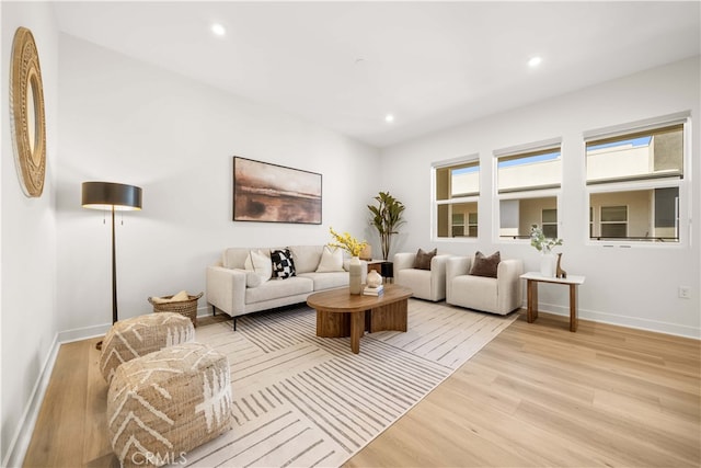 living area with baseboards, light wood-style flooring, and recessed lighting