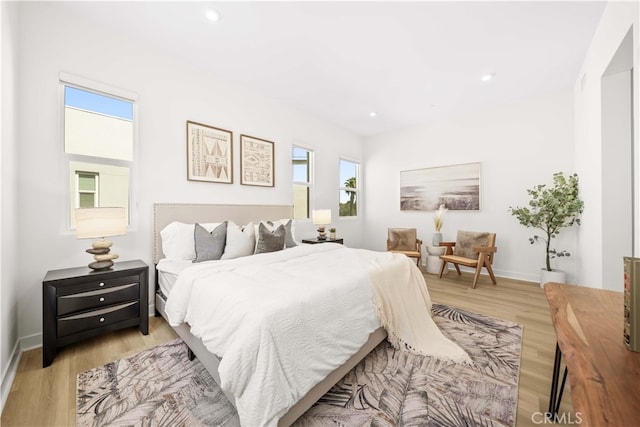 bedroom with light wood finished floors, baseboards, and recessed lighting