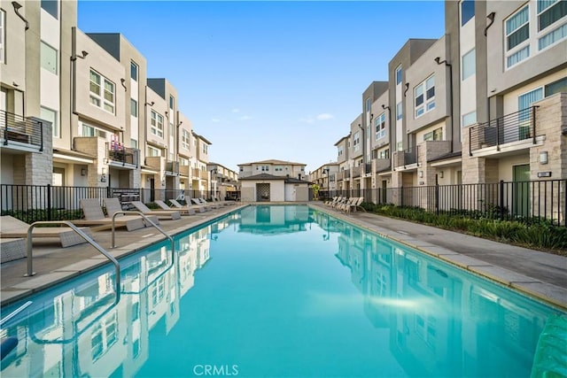 pool with a residential view, a patio area, and fence