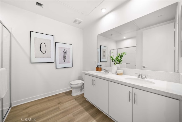 bathroom featuring a shower stall, visible vents, a sink, and wood finished floors