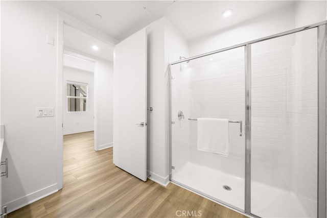 bathroom featuring a stall shower, baseboards, wood finished floors, and recessed lighting