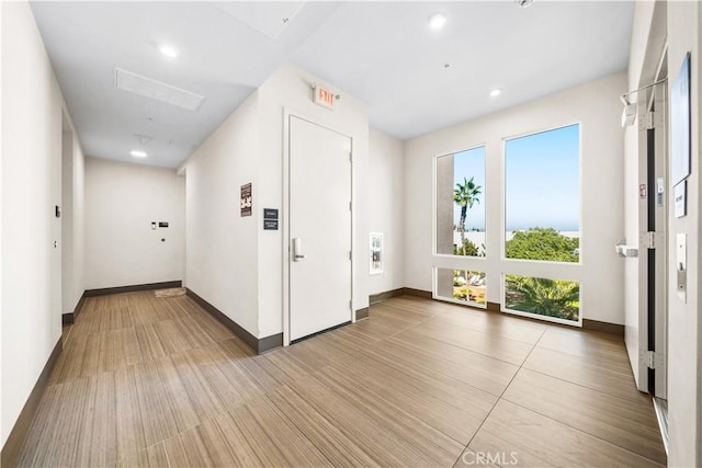 doorway to outside featuring recessed lighting, light wood-type flooring, and baseboards