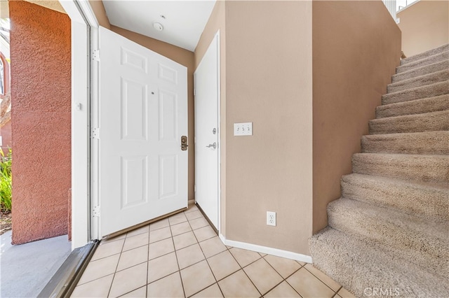 foyer featuring light tile patterned floors and stairway