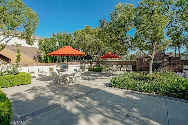 view of patio with outdoor dining area and fence