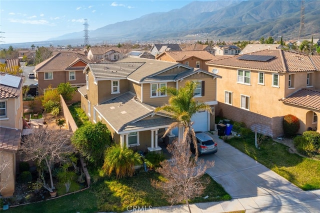 view of front of property with a mountain view, driveway, a residential view, and stucco siding