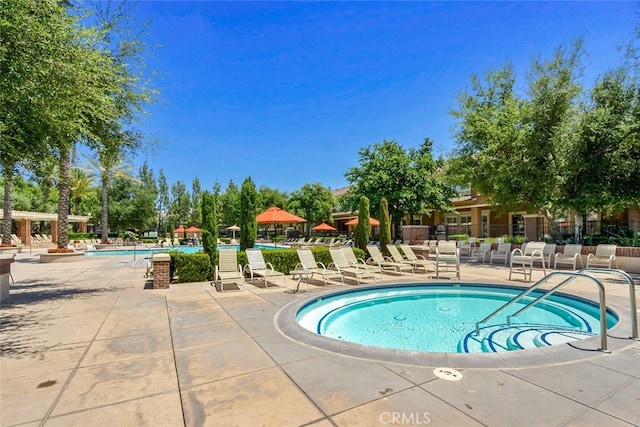 pool featuring a patio area, fence, and a hot tub