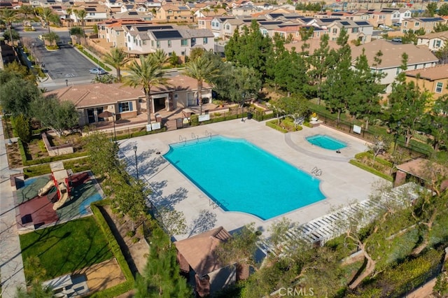 view of swimming pool with a residential view and fence