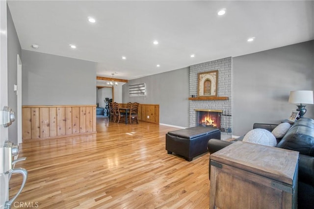 living area with light wood-type flooring, a fireplace, and recessed lighting