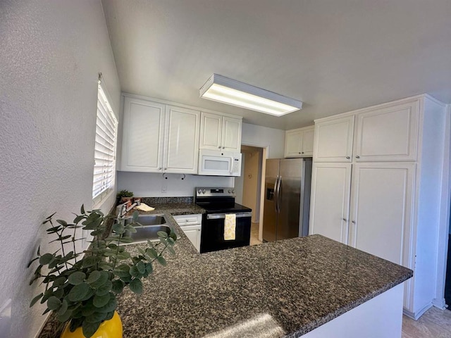 kitchen featuring stainless steel appliances, a peninsula, a sink, and white cabinetry