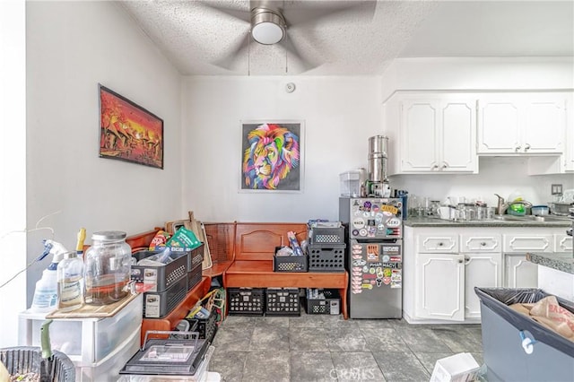 kitchen with white cabinetry, ceiling fan, and a textured ceiling